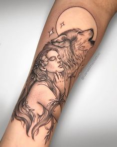 a woman's arm with a wolf and moon tattoo on the left side of her body