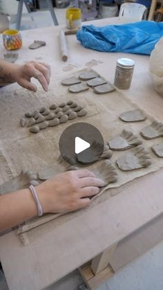 a woman is making pottery on a table