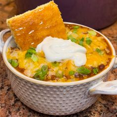 a close up of a bowl of food with a piece of bread on top of it