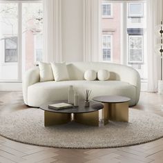 a white couch sitting on top of a living room floor next to a coffee table