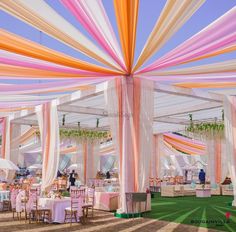 the inside of a tent with tables and chairs set up for a wedding or other function