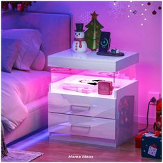 a white night stand with two drawers and a snowman on it in front of a christmas tree