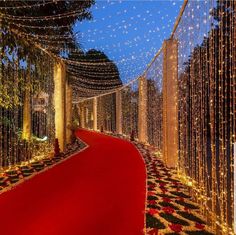 a red carpeted walkway is decorated with lights and garlands