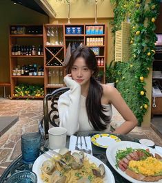 a woman sitting at a table with plates of food