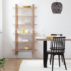 a dining room table and chairs with plates on them in front of a book shelf