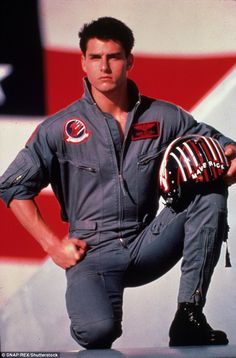 a man is posing in front of an american flag