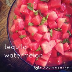 watermelon in a bowl with mint leaves on top and the words tequila watermelon above it