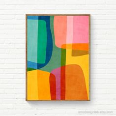 an abstract painting hangs on a white brick wall