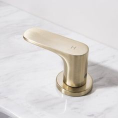 a gold faucet sitting on top of a white counter