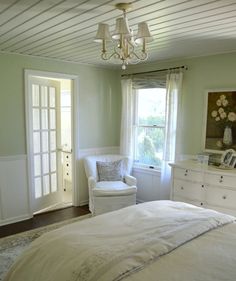 a bedroom with white furniture and green walls