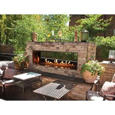 an outdoor fireplace in the middle of a patio