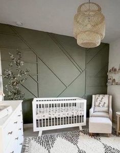 a baby's room with a white crib, dresser and chair in it