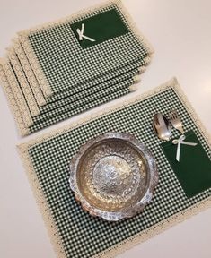 placemats and silverware are laid out on a green checkered tablecloth