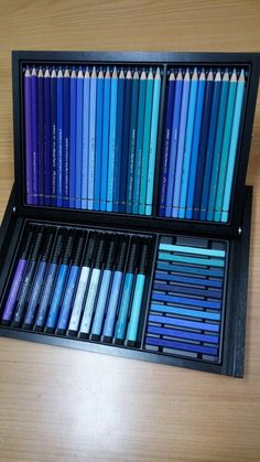 an open black box filled with different colored pencils