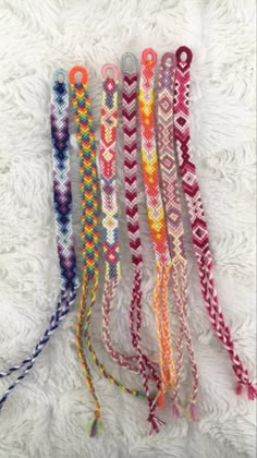 several different colored bracelets on a white blanket