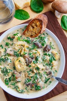 a bowl of soup with bread and spinach