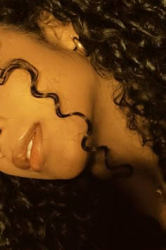 a close up of a doll with curly hair on her head and eyes closed to the camera