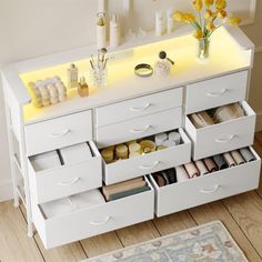 a white dresser with drawers and yellow lights