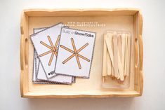 a wooden tray with matches and sticks in it