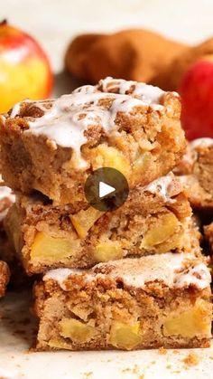 apple pie bars stacked on top of each other with apples and cinnamon in the background