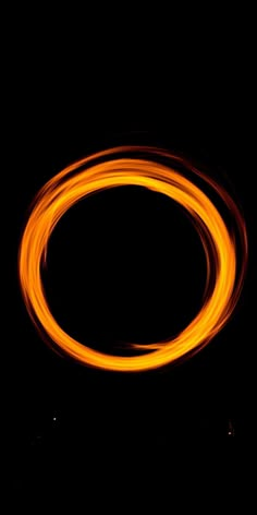 an orange ring is in the dark with light from it's reflection on its surface