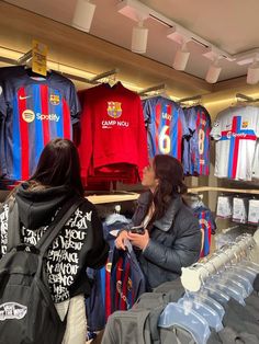 two women looking at shirts in a store