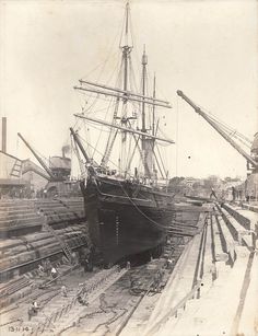 an old black and white photo of a ship in dry dock with other ships nearby