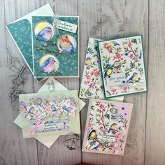 some cards are laying on a table with flowers and birds in them, one has a card that says happy mother's day