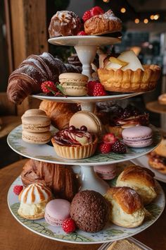 three tiered trays filled with different types of pastries and desserts on top of each other