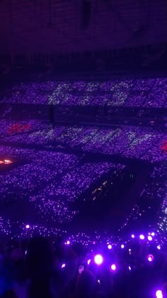 the stage is lit up with purple lights and people are looking at it from above