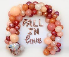 a balloon arch that says fall in love