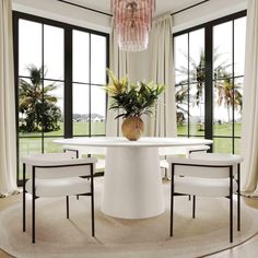 a dining room table surrounded by white chairs