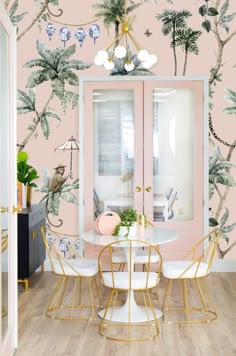 a dining room with pink walls and palm trees on the wall, along with white chairs