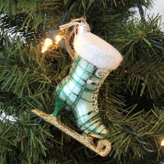 a christmas ornament hanging from a tree with snow boots and lights on it