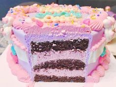 there is a large piece of cake with pink frosting and sprinkles