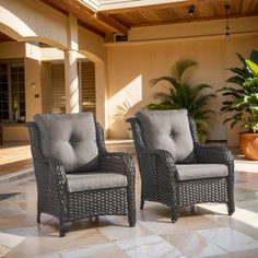 two wicker chairs sitting on top of a tiled floor