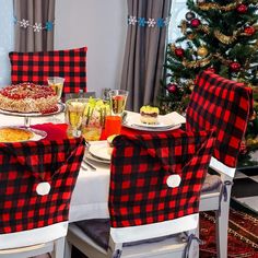 a dining room table set up for christmas with red and black buffalo plaid chair covers