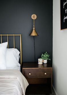 a bed room with a neatly made bed and a night stand