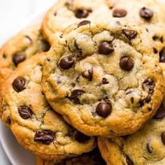 chocolate chip cookies piled on top of each other in a white plate with a fork