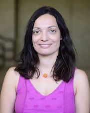 a woman in a purple top smiling for the camera