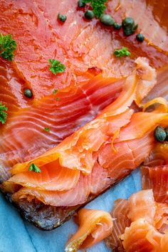 two pieces of fish on top of a piece of paper next to other food items