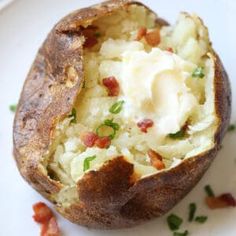 a baked potato on a white plate topped with sour cream