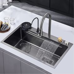 a stainless steel kitchen sink with two faucets and soap dispensers