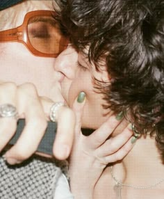 a man and woman kissing each other while wearing glasses