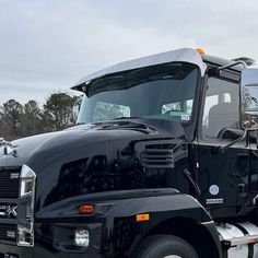 a large black truck parked in a parking lot