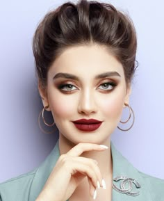 a woman with red lipstick and large hoop earrings on her head is posing for the camera