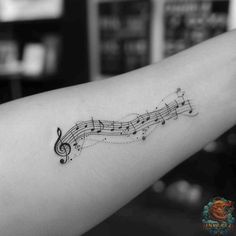 a musical note tattoo on the arm