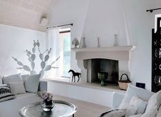 a living room with white furniture and a fireplace