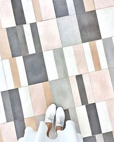 a person standing in front of a tiled floor with their feet up on the ground