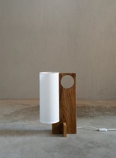 a white and wooden object sitting on top of a cement floor next to a wall